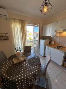 a kitchen and a dining room table with a tablecloth on at Apartmani Lucija in Zadar