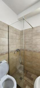 a bathroom with a toilet and a glass shower at Summer Apartments in Shengjin in Shëngjin