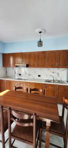 a kitchen with a wooden table and wooden cabinets at Summer Apartments in Shengjin in Shëngjin