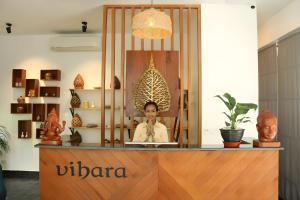 a woman is sitting at a counter in a store at Vihara The City of Temples in Siem Reap