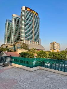 a green fence in front of some tall buildings at Landmark Guest House in Islamabad