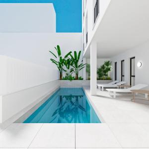 an indoor swimming pool with blue water in a building at Valencia Living Suites in Picanya