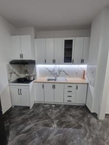 a kitchen with white cabinets and a sink at Summer Apartments in Shengjin in Shëngjin