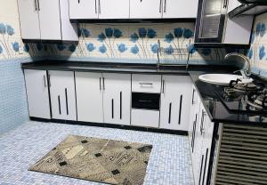 a kitchen with white cabinets and a sink at Afghan Arya Guest House & Tours in Kabul