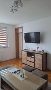 a living room with a flat screen tv on a entertainment center at Apartman MAGNIFICO in Donje Mladice