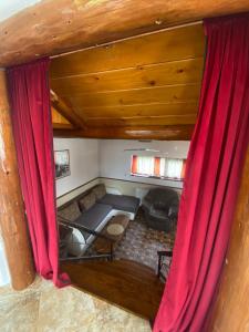 sala de estar con cortinas rojas y sofá en Vila Decebal, en Râșnov