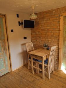 a wooden table with two chairs and a tv on a brick wall at Holidayapartement Sentjur 2 pers in Šentjur