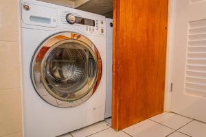 a white washing machine sitting in a room at Loft Apartment Ocean View in Saint Johnʼs