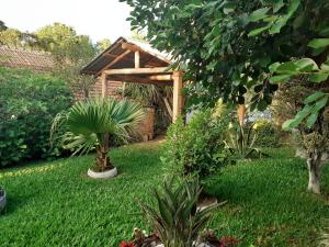 a garden with a wooden pergola in the grass at Cantinho do Sossego in Lages