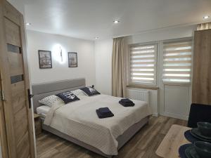 Un dormitorio con una cama con toallas azules. en AGWA - Pokój typu Studio, en Władysławowo