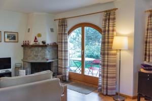 a living room with a fireplace and a sliding glass door at Chesa Filia - La Punt in La Punt-Chamues-ch
