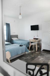 a room with two beds and a table with a mirror at On Sight Studio l in Myrties