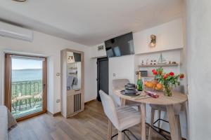 a kitchen and dining room with a table and a view of the ocean at Seafront Apartment Balcony Panoramic View in Kaštela