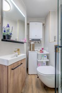 a bathroom with a sink and a toilet and a refrigerator at Seafront Apartment Balcony Panoramic View in Kaštela