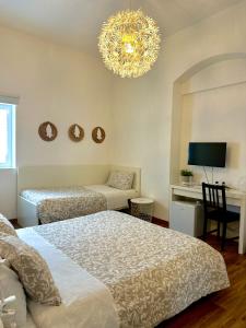 a bedroom with two beds and a chandelier at Matinee Rooms in Mattinata