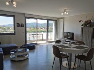 a living room with a couch and a table with chairs at DÉTENTE GARANTIE in Clermont-Ferrand