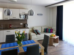 a kitchen and living room with a table and a couch at Apartamenty Marina Jastrzębia Góra in Jastrzębia Góra