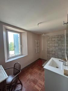 a bathroom with a sink and a chair and a window at Gîte de Montplo-Cruzy in Cruzy +8 photos