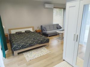 a bedroom with a bed and a couch in it at Mieszkanie Wakacyjne Na Wzgórzu in Chmielno