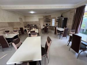 a room with tables and chairs and a kitchen at Sea Side in Ureki