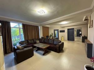 a living room with a leather couch and a table at Sea Side in Ureki