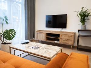 a living room with a couch and a tv at Apartament Vikicentrum in Bolesławiec