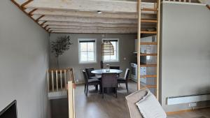 a dining room with a table and chairs and a loft at Tjeldsund Tide nr. 5 in Steinsland