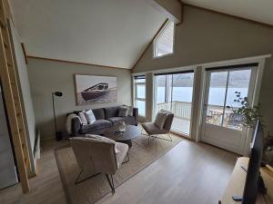 a living room with a couch and a table and chairs at Tjeldsund Tide nr. 5 in Steinsland