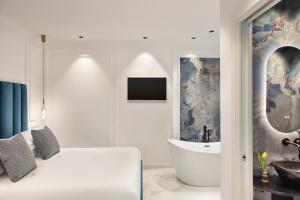 a white bedroom with a tub and a sink at Dama Luxury Suites Pompei in Pompei