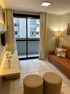 salon z kanapą i stołem w obiekcie Apartamento Beira Mar Pajuçara w mieście Maceió