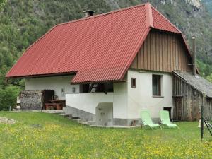a house with two chairs and a red roof at Idina domačija in Trenta +10 photos