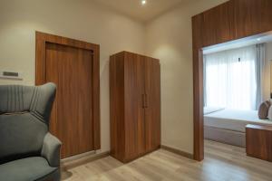 a bedroom with a closet and a bed and a chair at White House Royal Living in Jhānsi