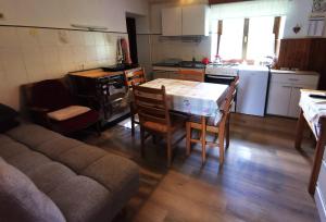a kitchen with a table and chairs and a table and a couch at Idina domačija in Trenta