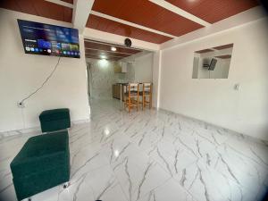 uma sala com uma cadeira verde e uma TV na parede em Apartamento Piso 1 Casa 6 Hotel Atlantis em Líbano