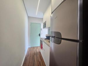 a kitchen with a stainless steel refrigerator at Studio on the best beach in Santos with parking included in Santos +4 photos
