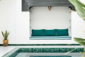a bench on a wall next to a swimming pool at Villa Dar Ambre in Marrakesh