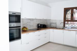 a white kitchen with white cabinets and appliances at Villa Dar Ambre in Marrakesh