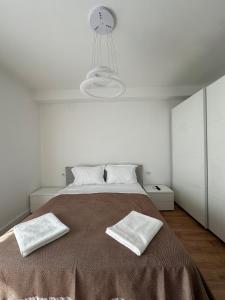 a white bedroom with a large bed with two white pillows at Aurela Apartment 1 in Lezhë