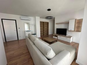 a living room with a couch and a television at Aurela Apartment 1 in Lezhë