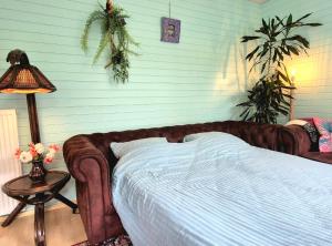 ein Schlafzimmer mit einem Bett und einem Tisch mit einer Lampe in der Unterkunft Bungalow Texel near beach and city centre in De Koog