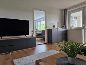 リンデンベルク・イム・アルゴイにあるFeWo Herz im Allgäu 2の大型薄型テレビのあるリビングルーム