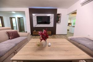 a living room with a table with flowers on it at Holiday Residence Šehić in Visoko