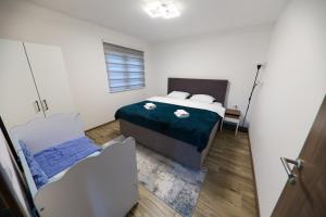 a small bedroom with a bed and a window at Holiday Residence Šehić in Visoko