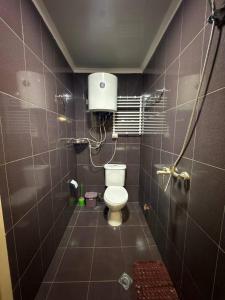a bathroom with a toilet in a tiled room at Sea Side in Ureki