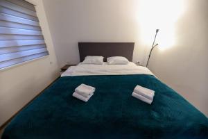 a bedroom with a bed with two towels on it at Holiday Residence Šehić in Visoko