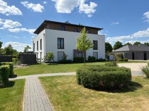 a white house with a tree in the yard at Brisare in Göhren-Lebbin