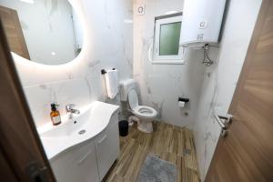 a white bathroom with a sink and a toilet at Holiday Residence Šehić in Visoko