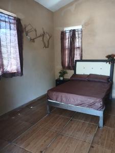 a bedroom with a bed and two windows at Cabaña de Descanso El garambullo in San Antonio de la Cal