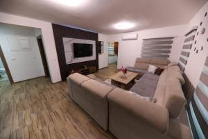 a living room with a couch and a tv at Holiday Residence Šehić in Visoko