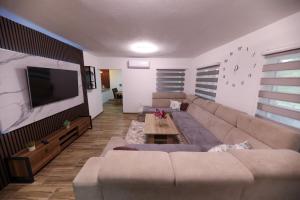 a living room with a couch and a flat screen tv at Holiday Residence Šehić in Visoko